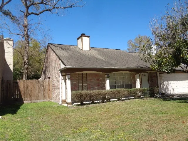 a front view of house with yard and trees in the background