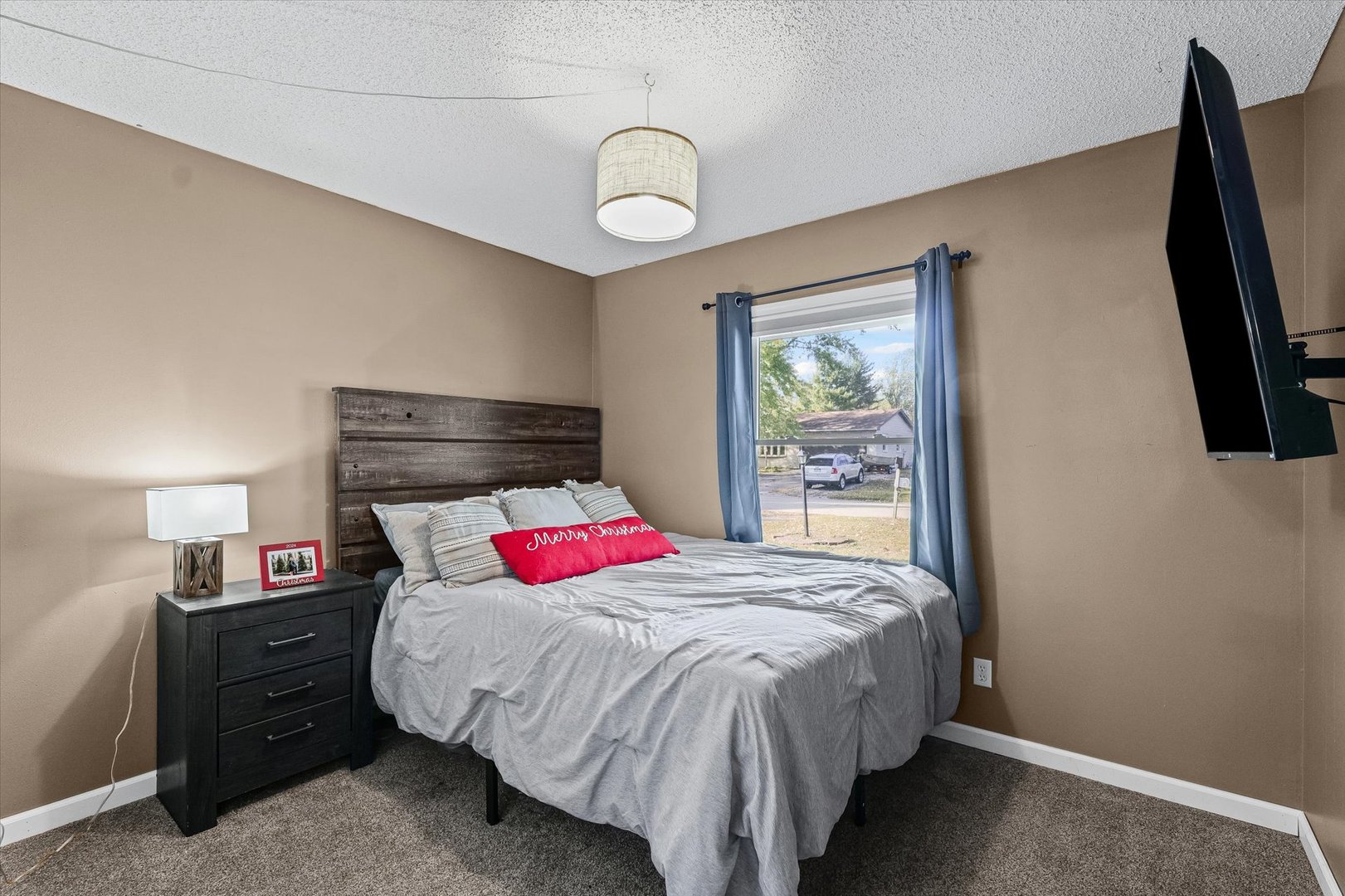 1715 Phillippe Drive Mahomet, IL 61853 - Photo 21 of 30 a bedroom with a bed and a flat tv screen on dresser