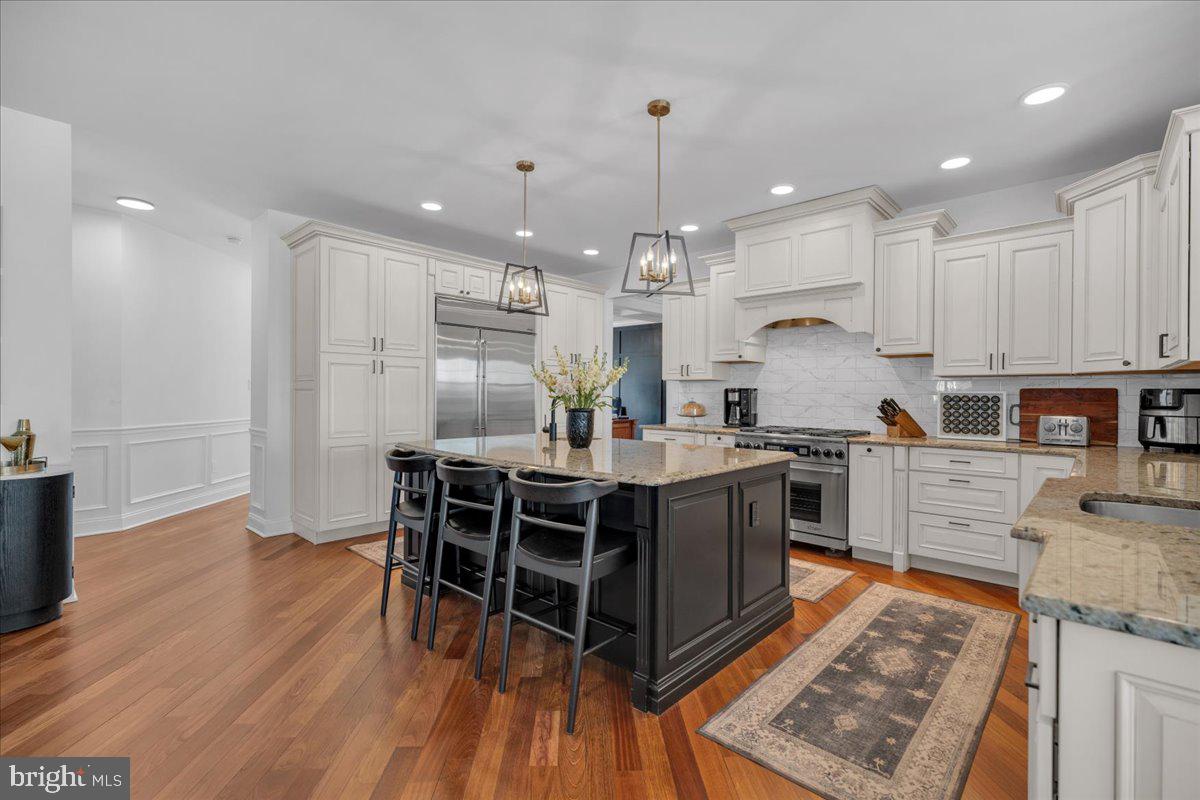 425 Peltoma Road Haddonfield, NJ 08033 - Photo 5 of 33 a kitchen with stainless steel appliances granite countertop a stove top oven a sink dishwasher a dining table and chairs with wooden floor
