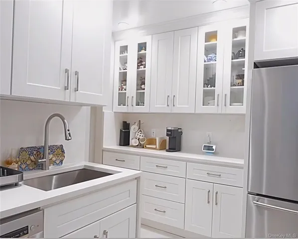 a kitchen with stainless steel appliances granite countertop white cabinets and sink