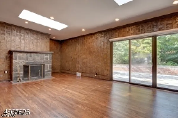 a view of empty room with wooden floor and fireplace