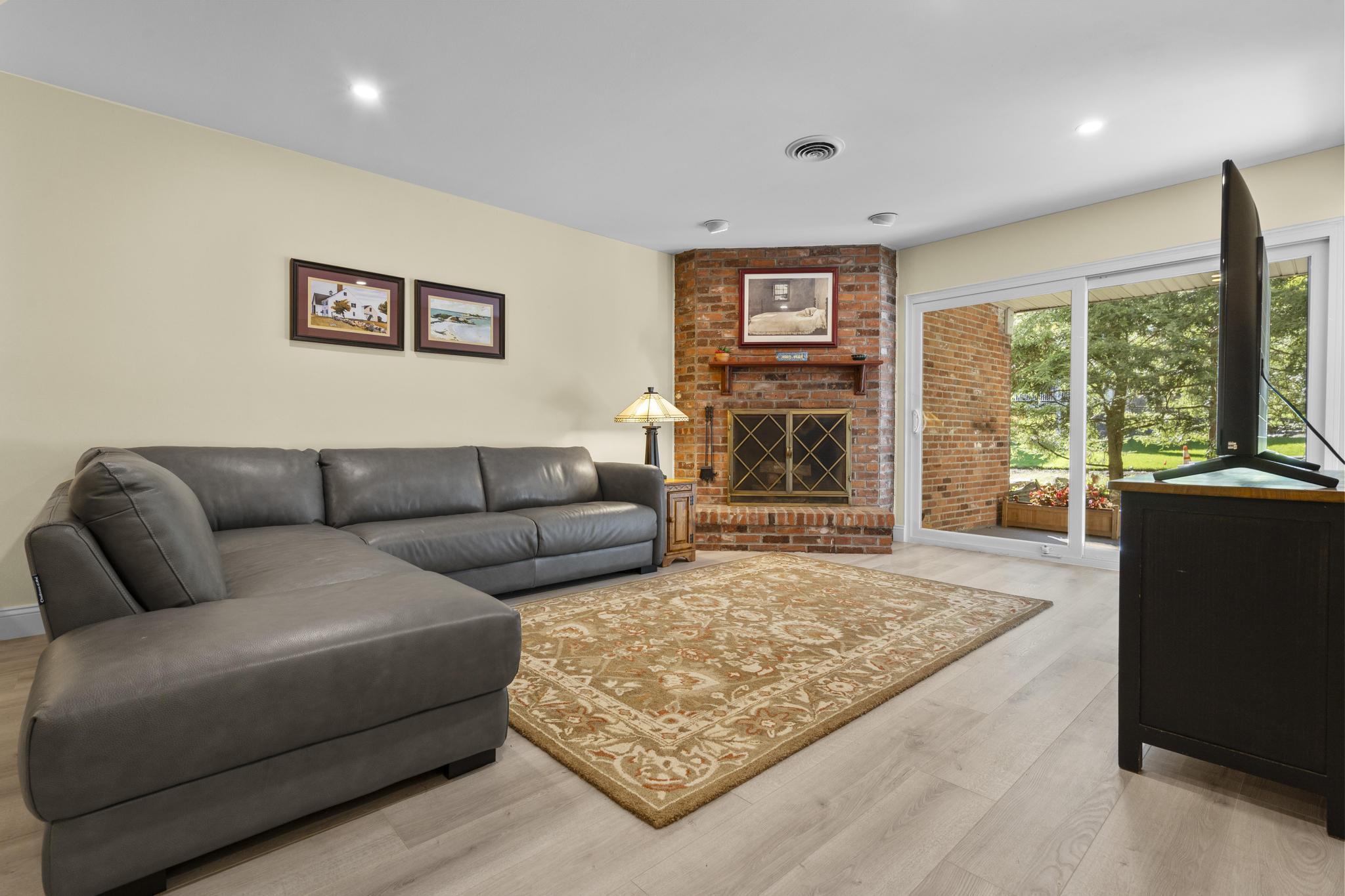 28 Mill Hill Road, Unit 28 Fairfield, CT 06890 - Photo 11 of 37 a living room with furniture large window and a fireplace