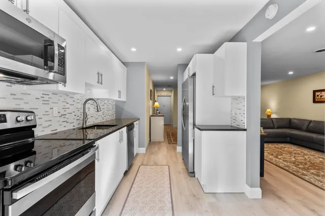 a kitchen with stainless steel appliances kitchen island granite countertop a stove a sink and a microwave