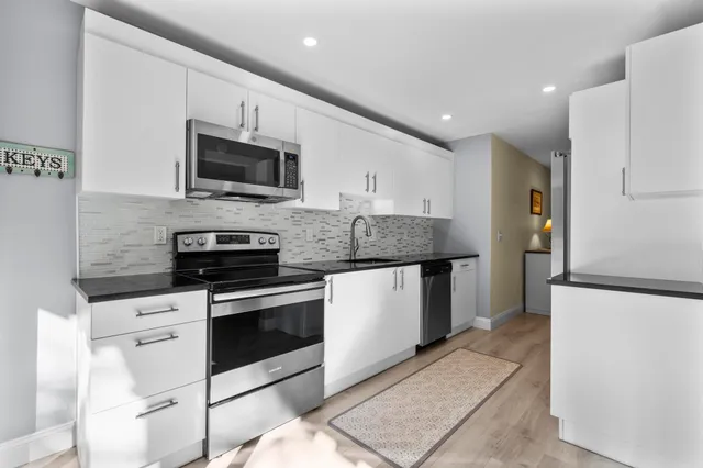 a kitchen with stainless steel appliances granite countertop a refrigerator and a sink