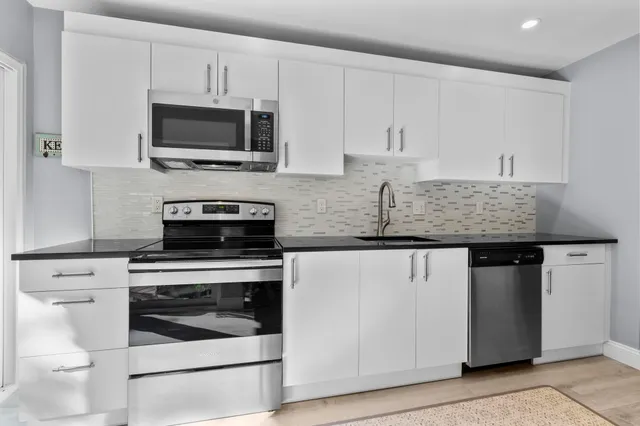 a view of a hallway with wooden floor and a bathroom