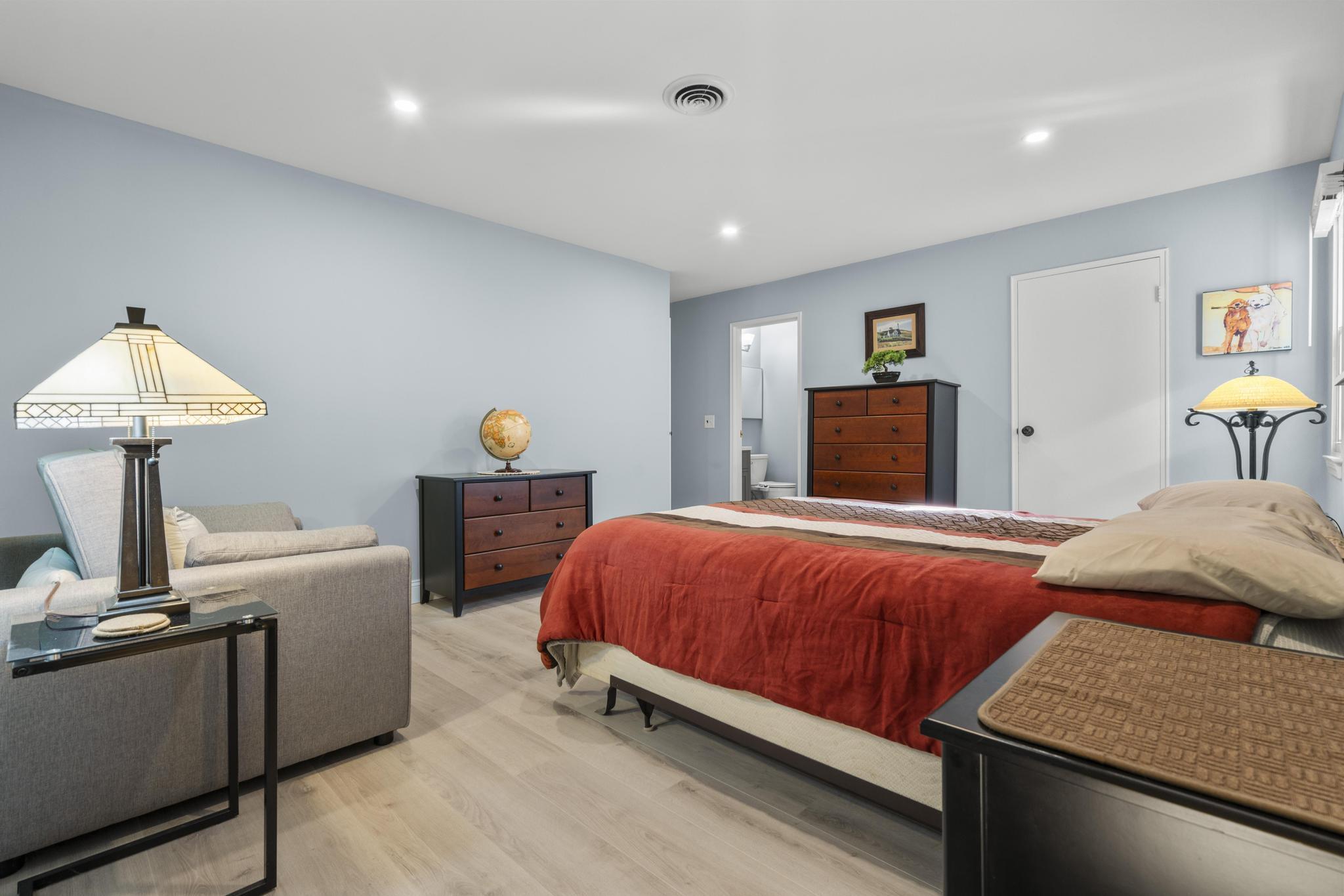 28 Mill Hill Road, Unit 28 Fairfield, CT 06890 - Photo 22 of 37 a bedroom with a bed and a chandelier