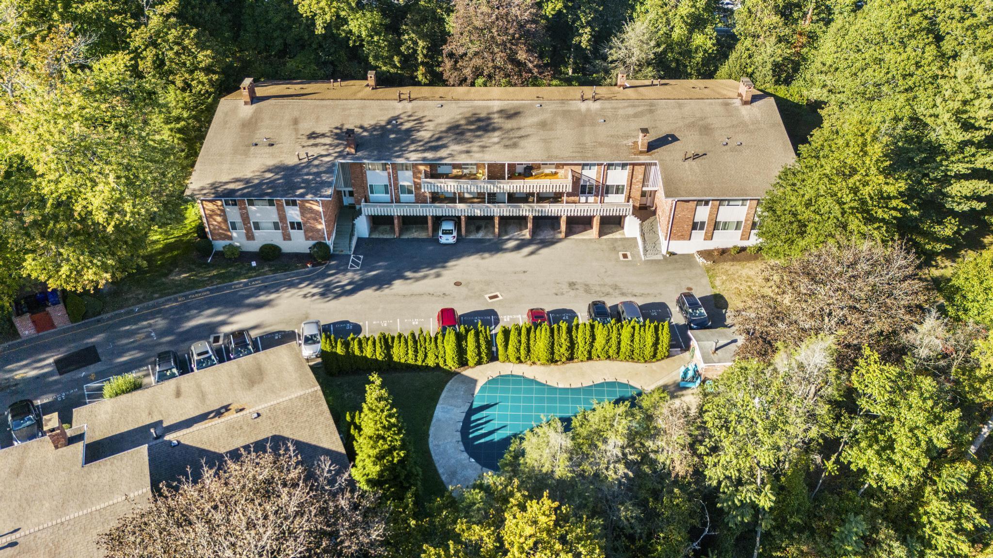 28 Mill Hill Road, Unit 28 Fairfield, CT 06890 - Photo 3 of 37 an aerial view of a house with swimming pool and large trees