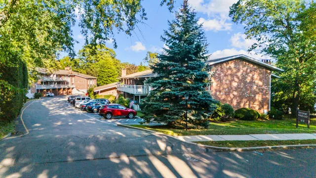 a sign of golf club on a wall under a tree