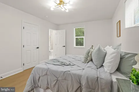 a spacious bedroom with a bed and chandelier