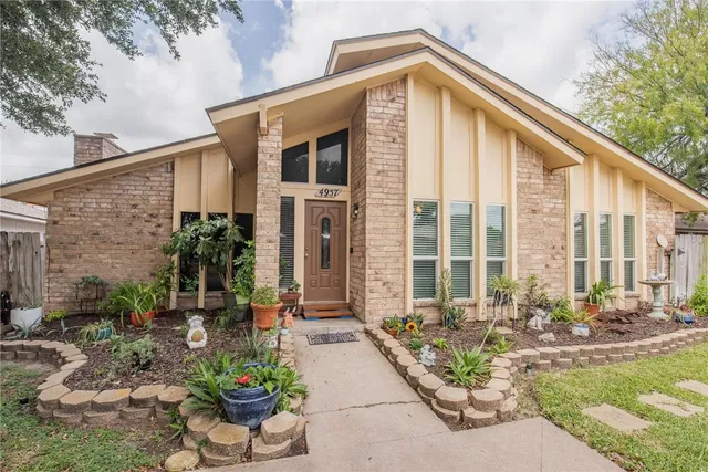 a front view of a house with swimming pool outdoor seating