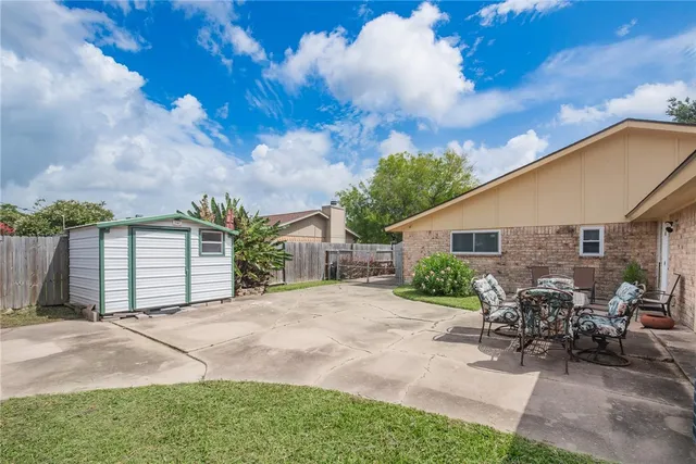 a view of a house with backyard and a tree