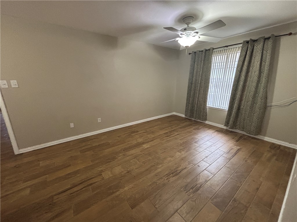 4957 Shadowbend Drive Corpus Christi, TX 78413 - Photo 23 of 35 an empty room with wooden floor fan and window