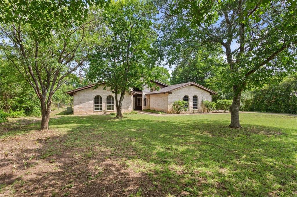 317 Chapman Road Hewitt, TX 76643 - Photo 5 of 20 Single-story residence featuring light-colored brick exterior, arched windows.Expansive front lawn.