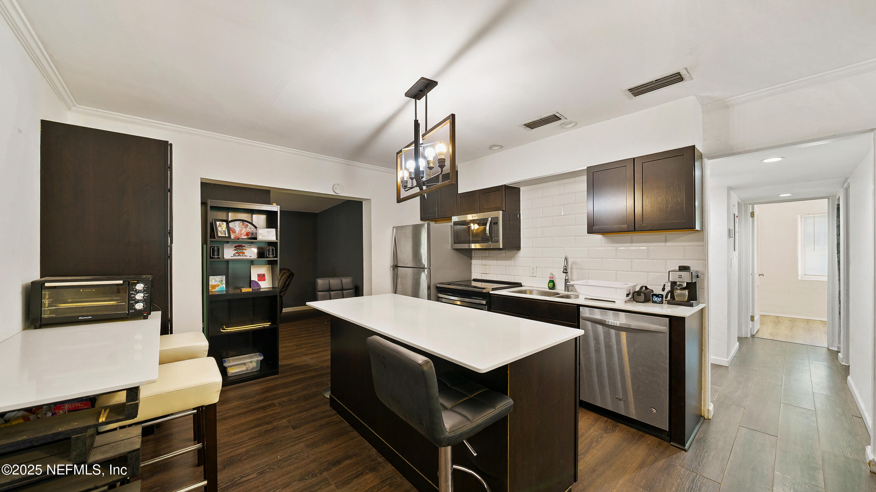 10555 Rutgers Road Jacksonville, FL 32218 - Photo 4 of 25 a kitchen with a stove a refrigerator wooden floor and a dining table