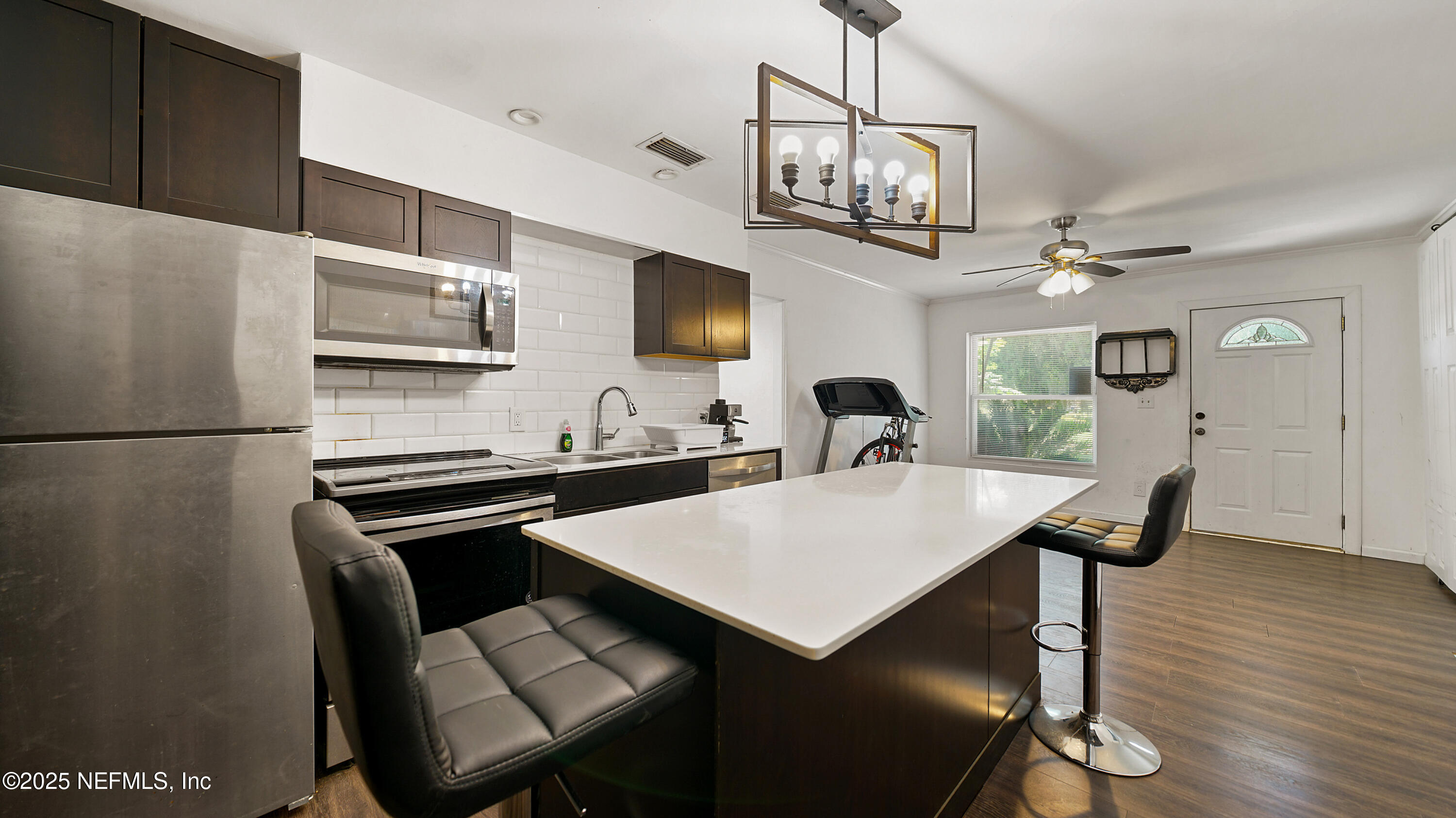 10555 Rutgers Road Jacksonville, FL 32218 - Photo 7 of 25 a kitchen with stainless steel appliances granite countertop a sink a stove a refrigerator a microwave oven with a dining table and chairs