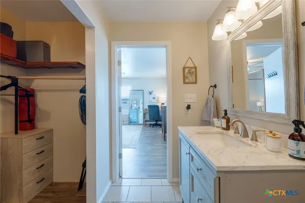 a en suite bathroom with a granite countertop sink and a mirror