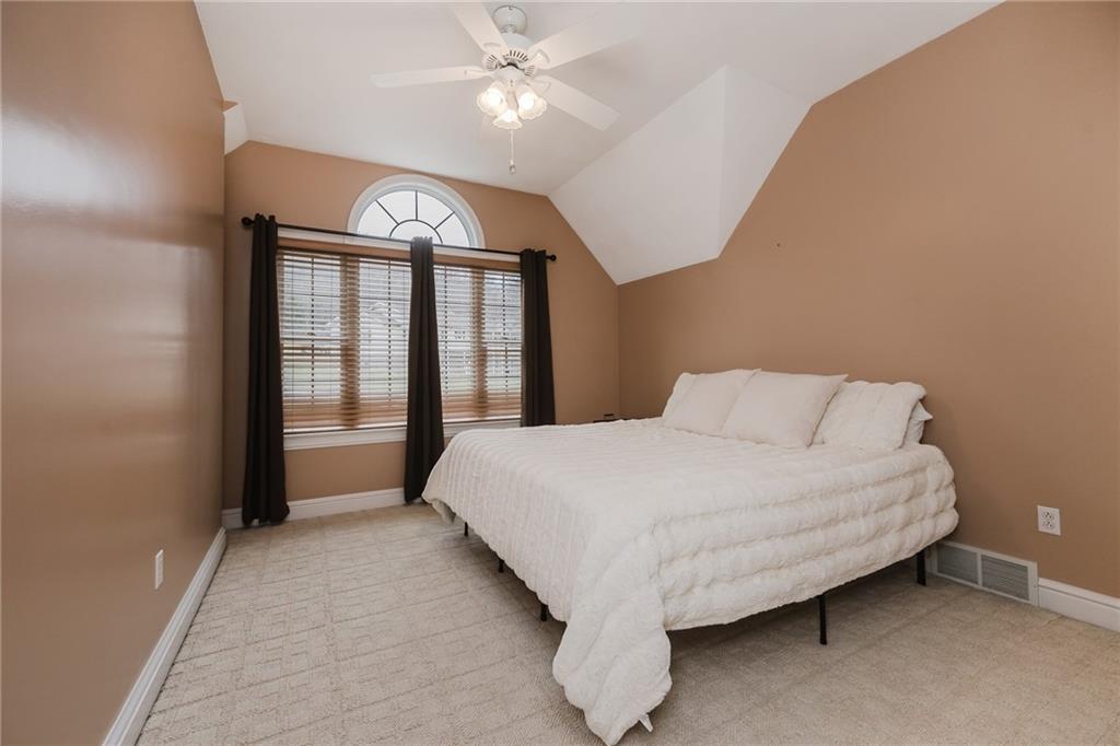 459 Forest Ridge Road Indiana, PA 15701 - Photo 31 of 45 a spacious bedroom with a large bed and a chandelier