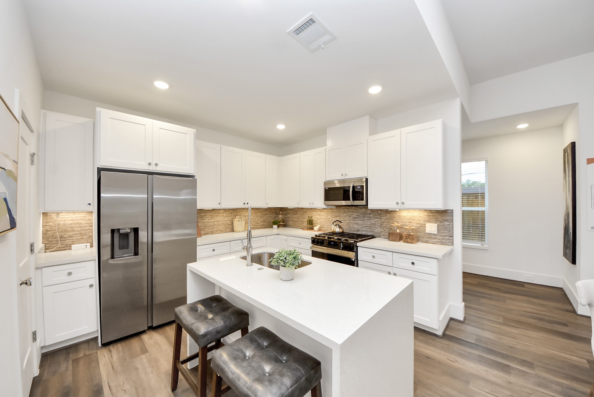7502 Carver Road, Unit A Houston, TX 77088 - Photo 12 of 48 a kitchen with a sink a refrigerator a stove and white cabinets with wooden floor