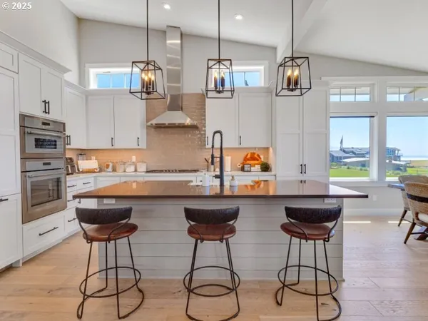 a kitchen with stainless steel appliances granite countertop a stove a sink and a refrigerator
