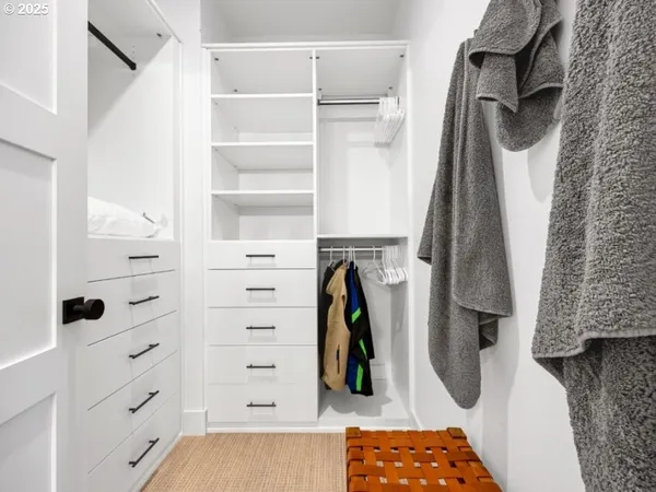 a view of walk in closet with clothes and shoes