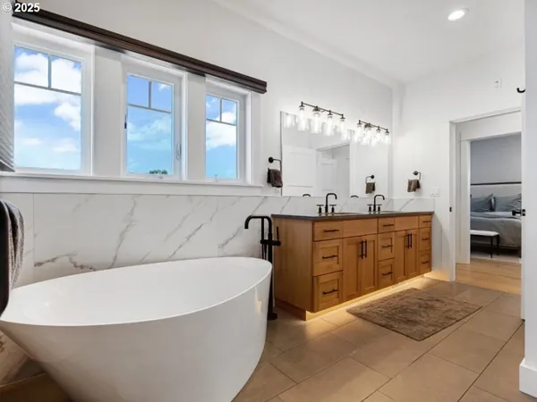 a spacious bathroom with a tub sink and mirror