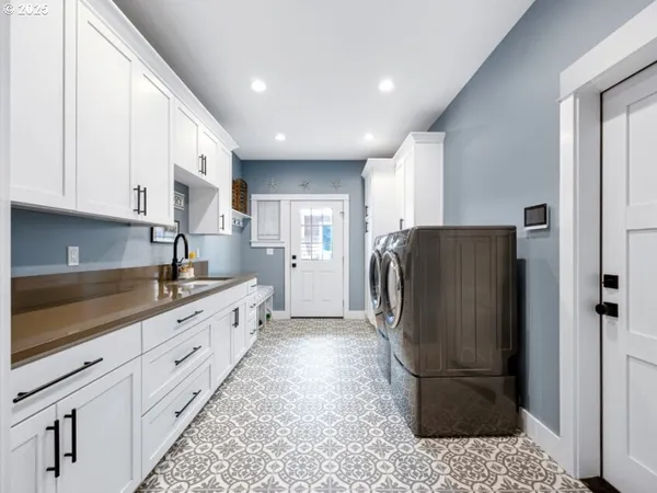 a kitchen with stainless steel appliances granite countertop a refrigerator a sink and white cabinets