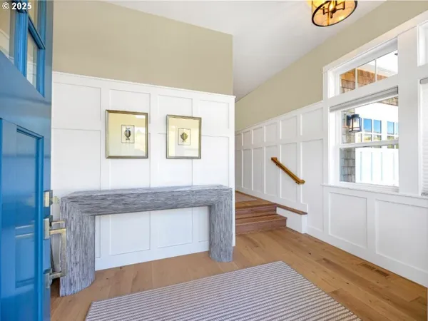 a hallway with stairs and wooden floor