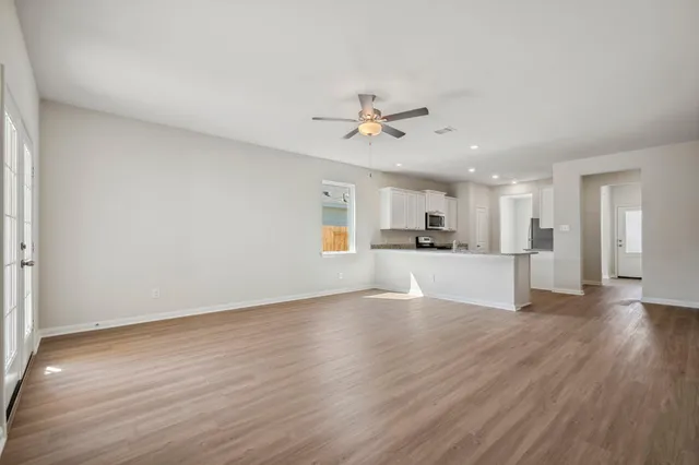 a view of a kitchen with wooden floor and a kitchen space