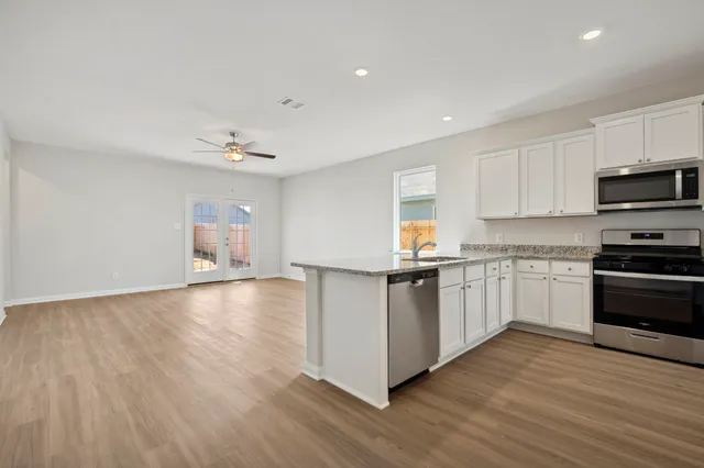 a kitchen with stainless steel appliances granite countertop a stove and a sink