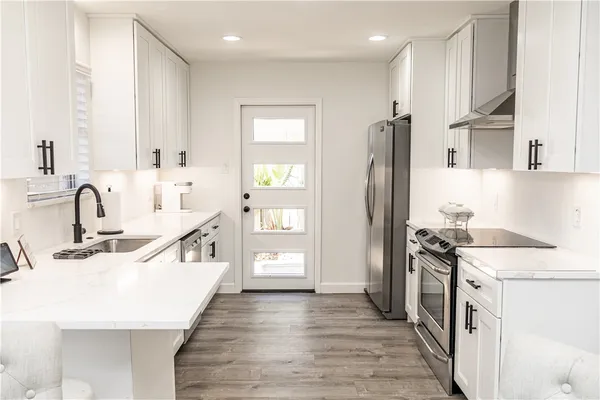 a kitchen with stainless steel appliances granite countertop a sink stove and refrigerator