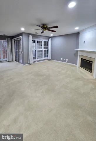 a view of an empty room with a fireplace and window