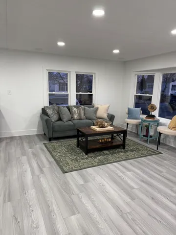 a living room with furniture and a wooden floor