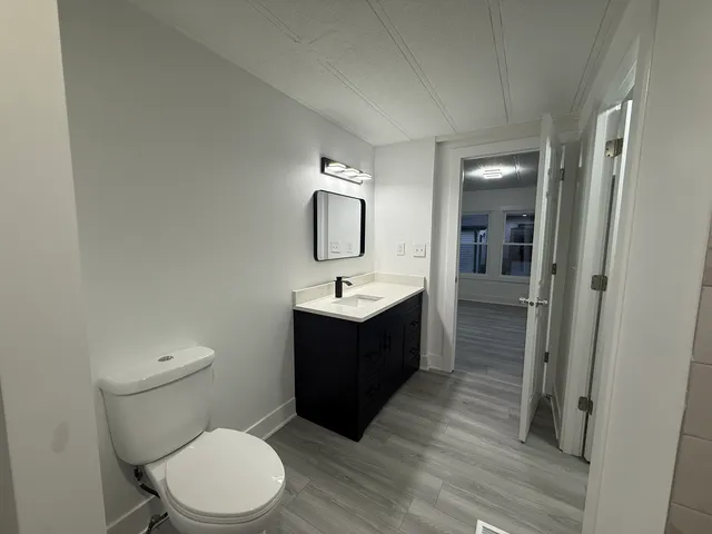 a bathroom with a toilet a sink and mirror