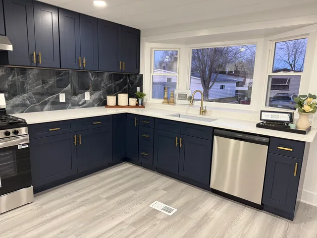 a kitchen with stainless steel appliances granite countertop a sink stove and cabinets