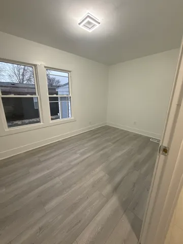 a view of an empty room with a fireplace and a window