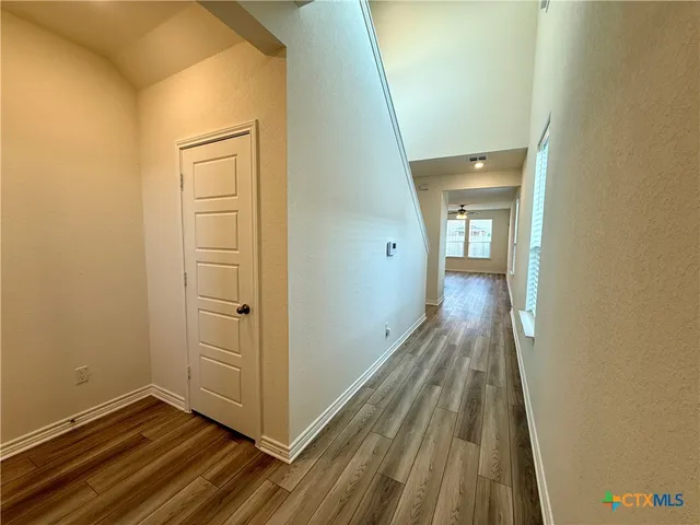 an empty room with windows and ceiling fan view