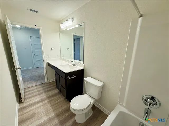 an empty room with a window and a ceiling fan