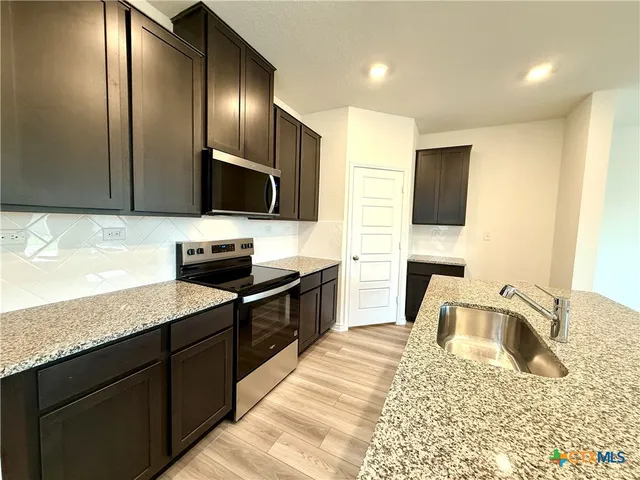 a large kitchen with kitchen island a sink dishwasher a stove and a refrigerator