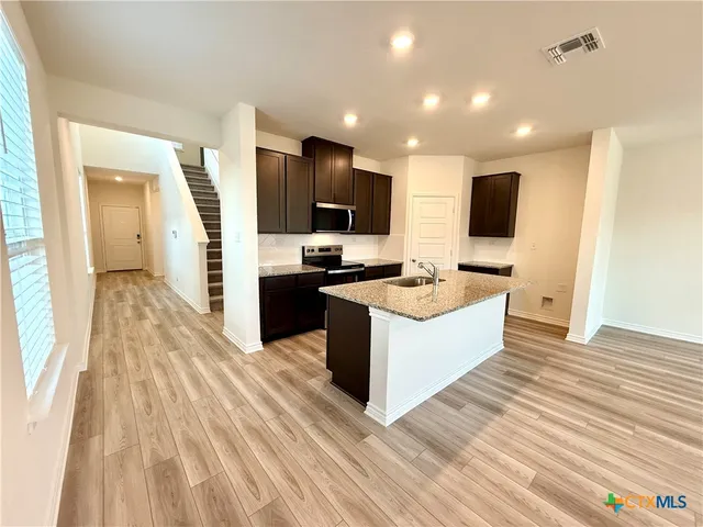 a spacious bathroom with a granite countertop sink and a mirror