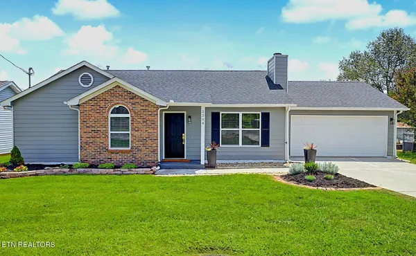 a front view of a house with a yard and green space