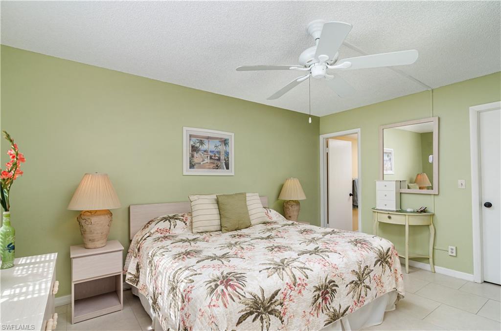 5499 Rattlesnake Hammock Road, Unit A206 Naples, FL 34113 - Photo 15 of 23 a bedroom with a bed and a chandelier