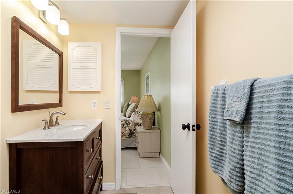 5499 Rattlesnake Hammock Road, Unit A206 Naples, FL 34113 - Photo 17 of 23 a bathroom with a sink and mirror