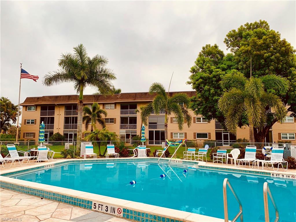 5499 Rattlesnake Hammock Road, Unit A206 Naples, FL 34113 - Photo 23 of 23 a view of a patio with swimming pool table and chairs
