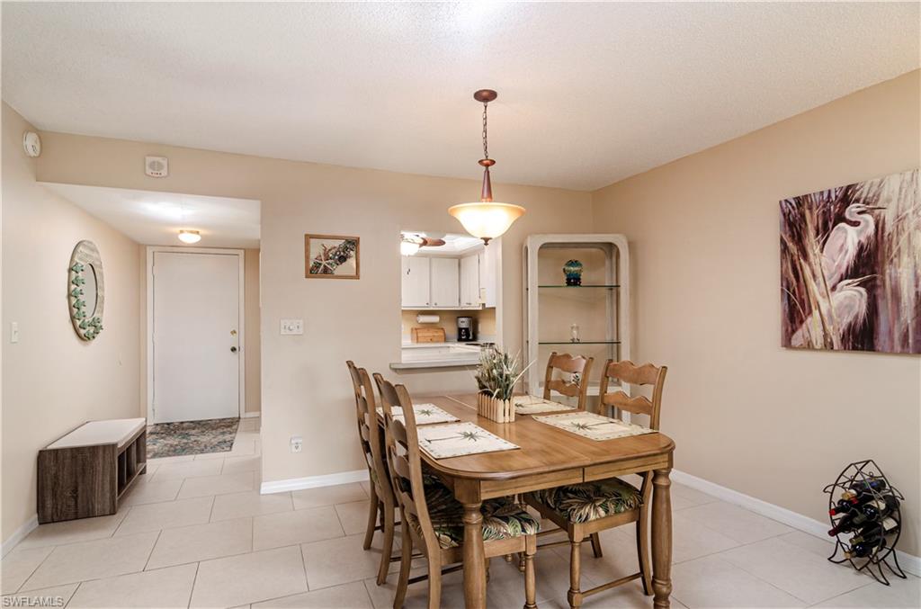 5499 Rattlesnake Hammock Road, Unit A206 Naples, FL 34113 - Photo 5 of 23 a view of a dining room with furniture and a chandelier