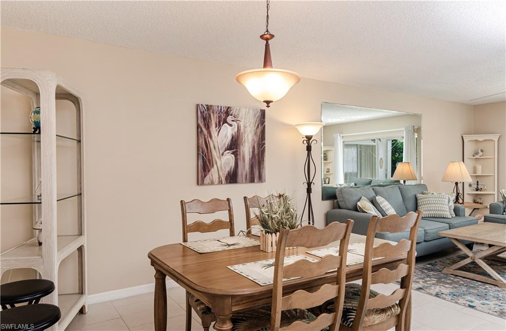 5499 Rattlesnake Hammock Road, Unit A206 Naples, FL 34113 - Photo 6 of 23 a view of a dining room with furniture and a chandelier