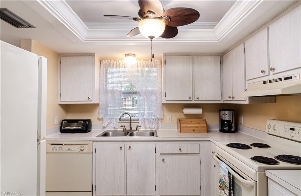 5499 Rattlesnake Hammock Road, Unit A206 Naples, FL 34113 - Photo 7 of 23 a kitchen with a sink a stove and cabinets