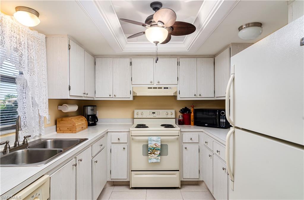 5499 Rattlesnake Hammock Road, Unit A206 Naples, FL 34113 - Photo 8 of 23 a kitchen with white cabinets and white appliances