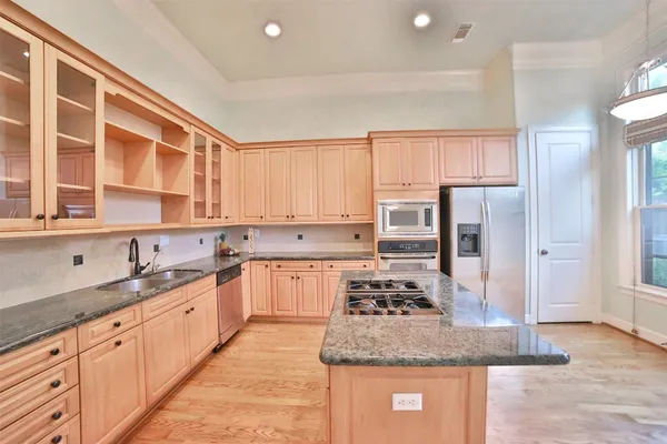 a kitchen with stainless steel appliances granite countertop a sink stove and refrigerator