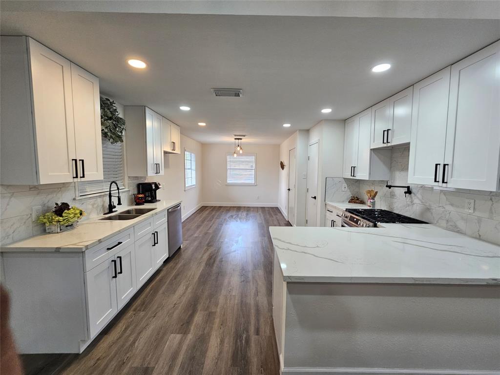 a large kitchen with stainless steel appliances lots of counter space and wooden floor