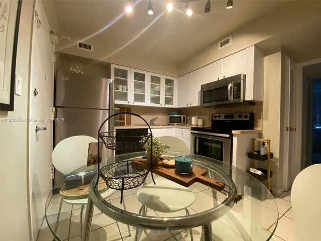 a kitchen with stainless steel appliances a stove a sink a microwave and dining table
